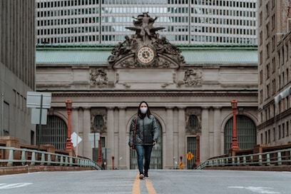 Masked NYC woman, emblematic of pandemic impact on city life.